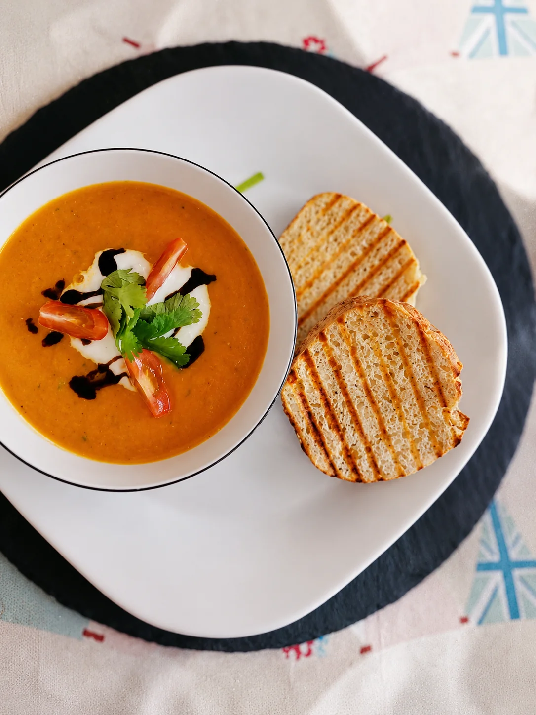 A bowl of tomato soup served with toasted bread at Fifteas